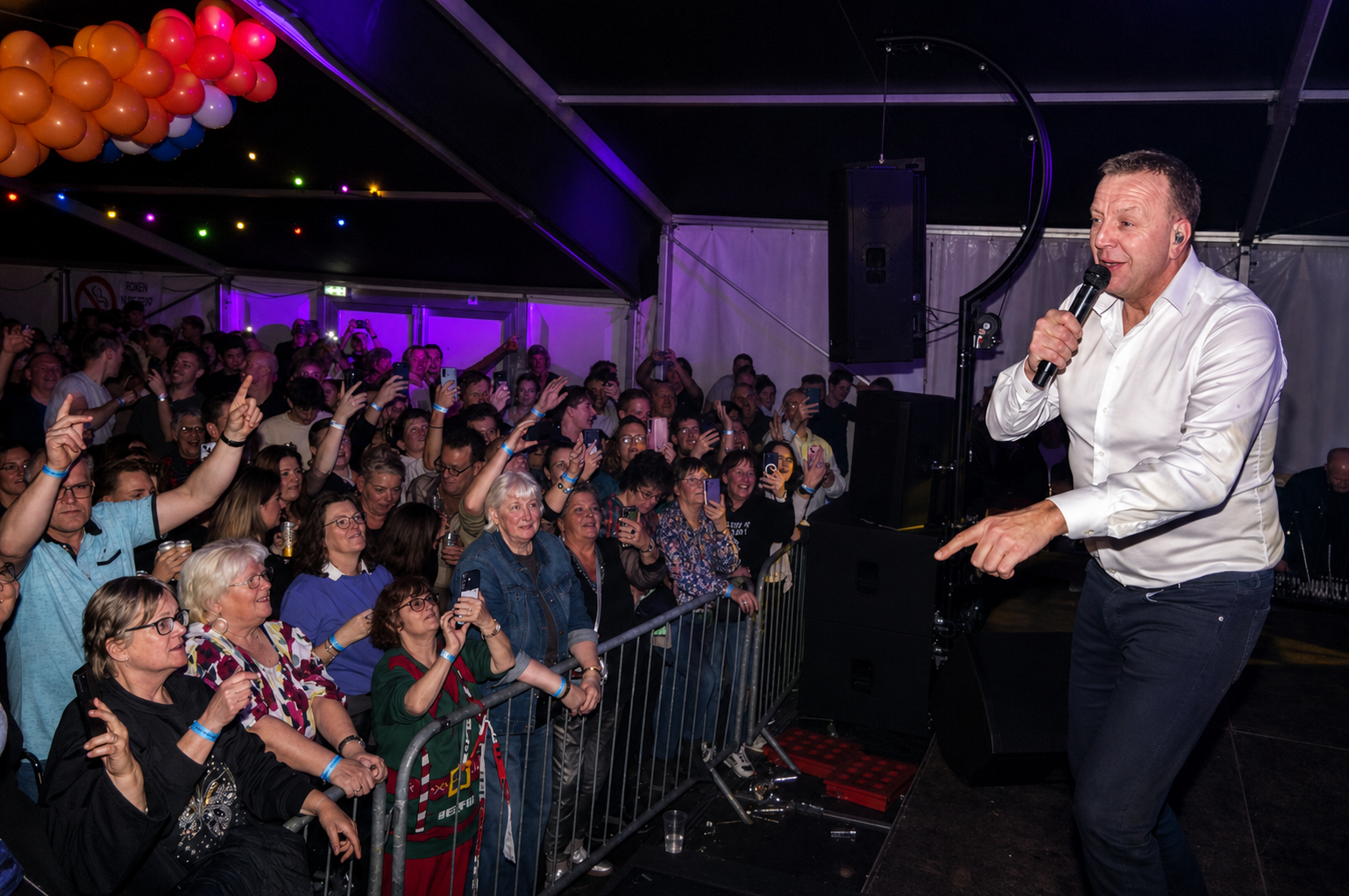 Artiest op het podium met meezingend publiek